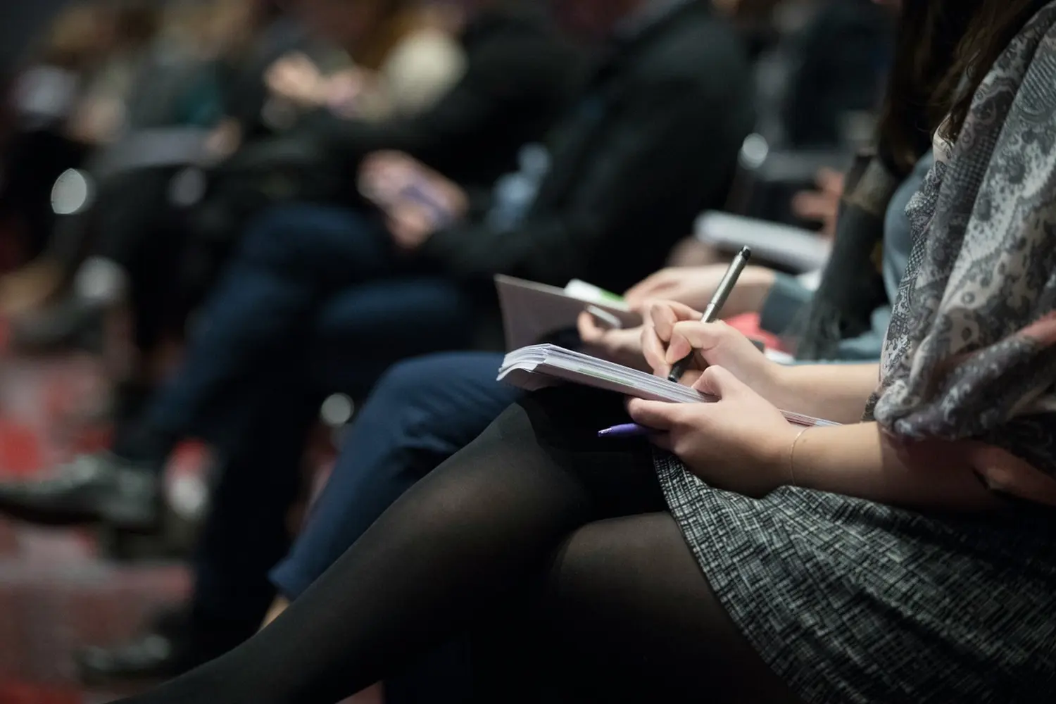 Frau schreibt auf Notizbuch von konzept Consulting Unternehmensberatung